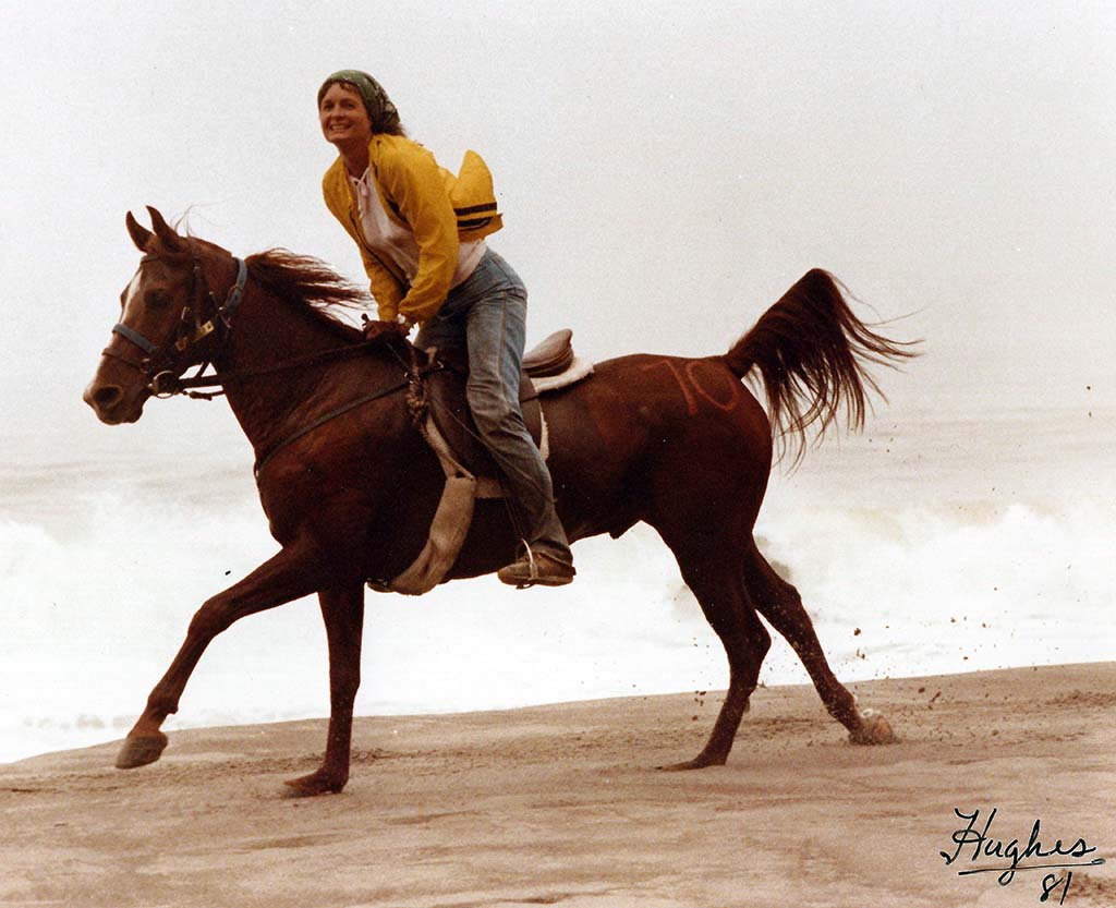 Linda riding along the beach